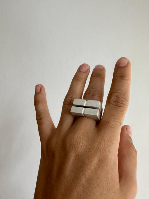 Imagen de mano usando anillo de plata inspirado en arquitectura 