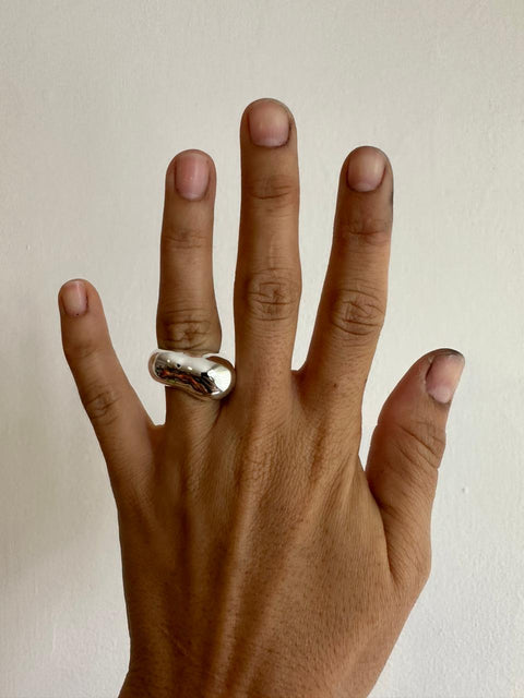 mano con anillo curvo reflejo anillo plata