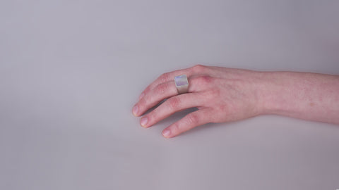 Imagen de mano con anillo de plata tipo signet con incrustación de madre perlaano con anil